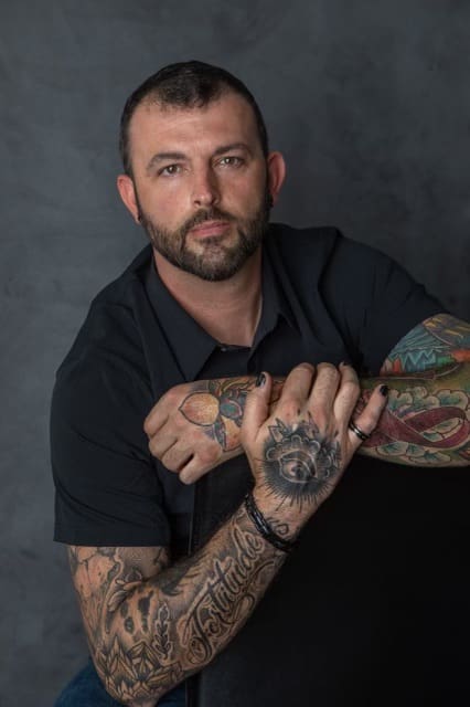 6723ac4441be0_20230319_ A man with tattoos on his arms and hands.